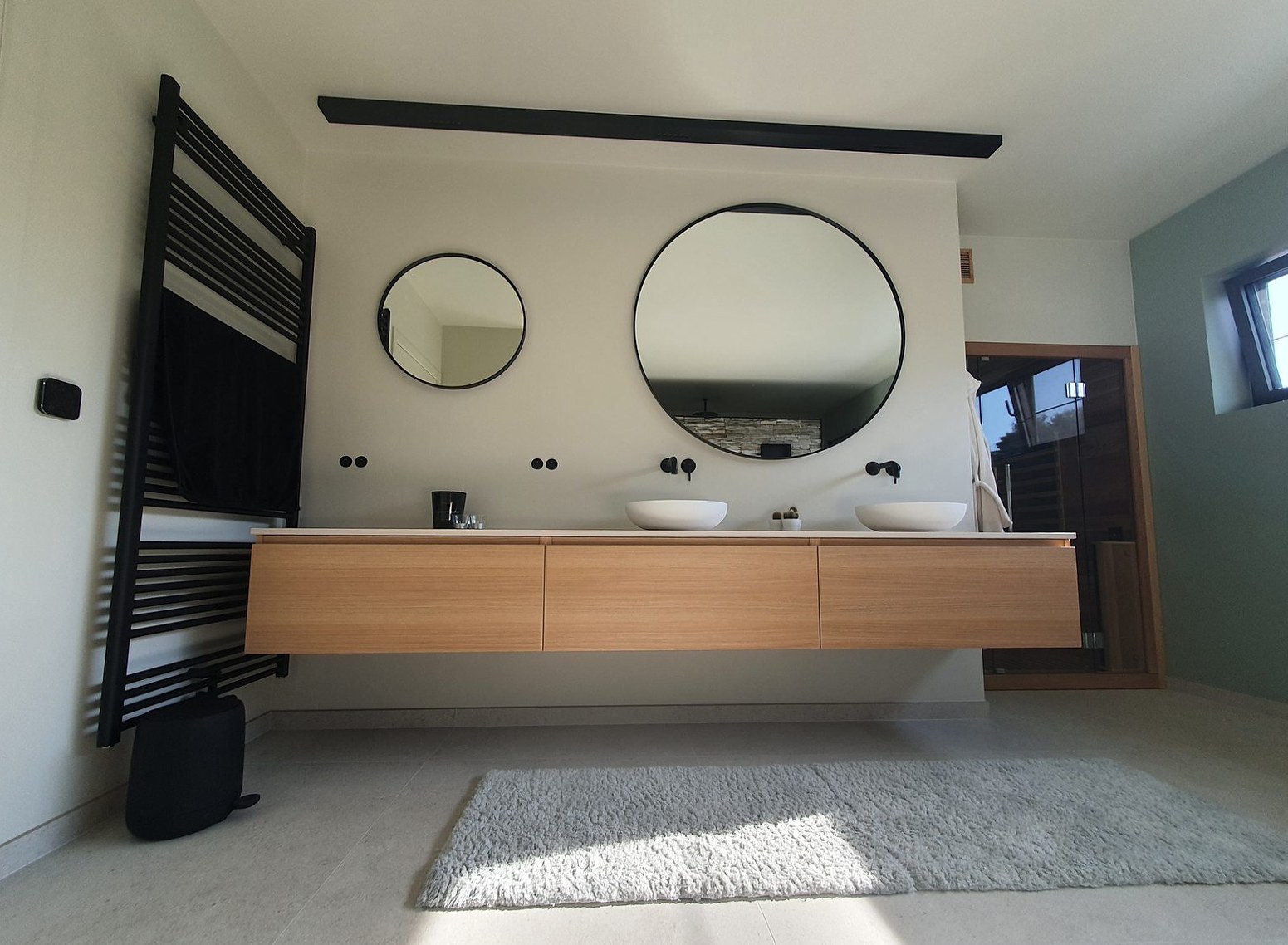 Dubbel zwevend badmeubel in hout, ronde zwarte spiegels en zwarte designradiator