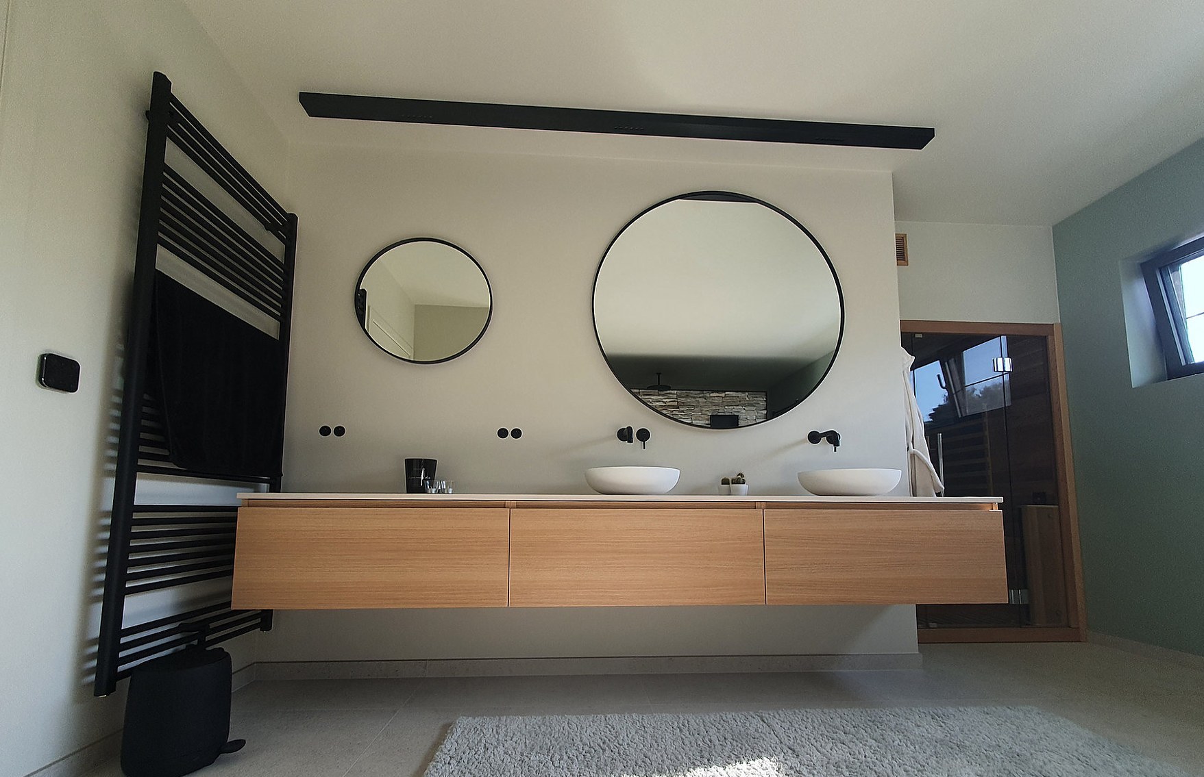 Badkamer met natuursteenwand en vrijstaand bad