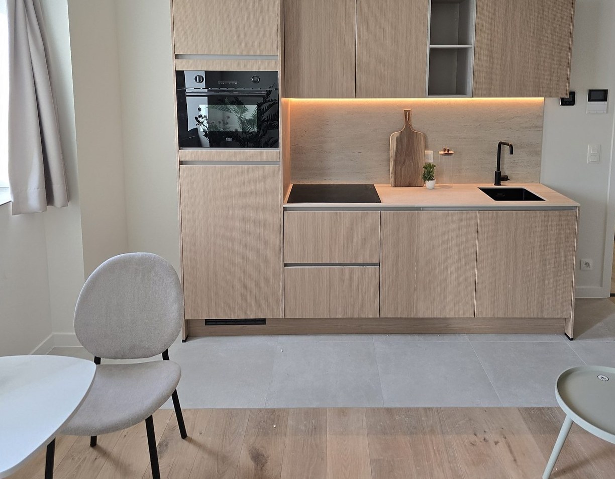 Rechte keuken in licht hout met inbouwoven, open vak en verlichte achterwand