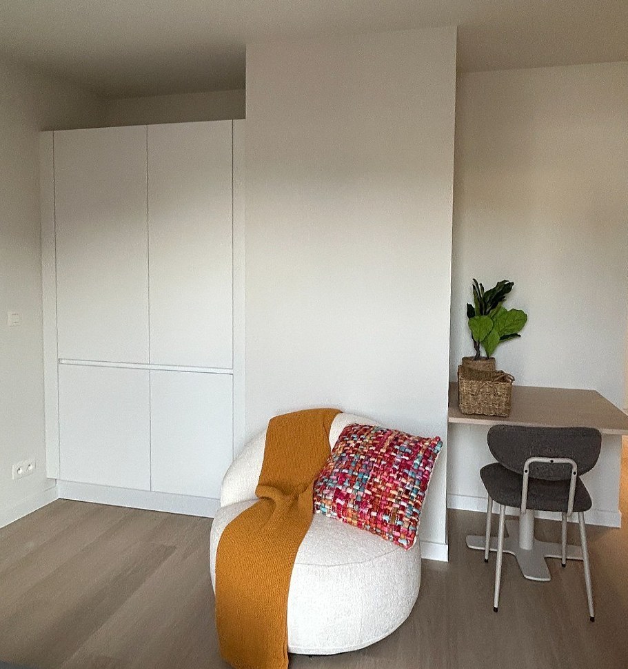 Witte grepeloze kasten in een studio met zithoek en eethoekje